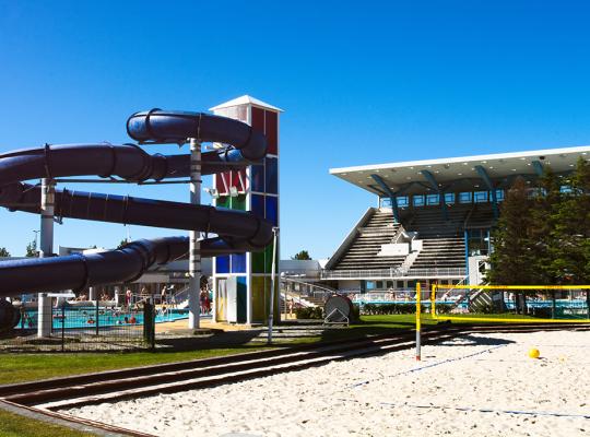 Beach volleyball court, large slide, and grandstand at Laugardalslaug Pool