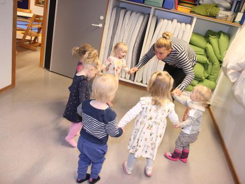 Leikskólabörn með kennara sínum.
