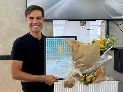 Dario Nunes með blómvönd og viðurkenningarskjal á Íslensku lýsingarverðlaununum.
