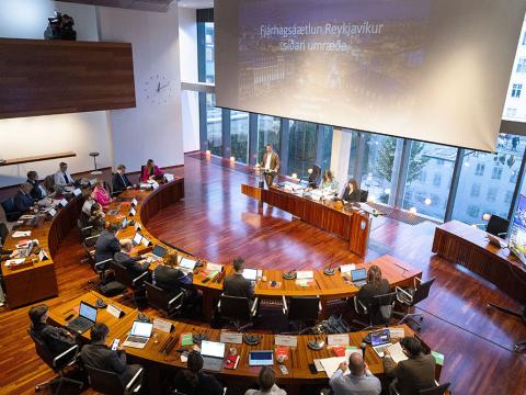 Horft af svölum í fullsetinn borgarstjórnarsal