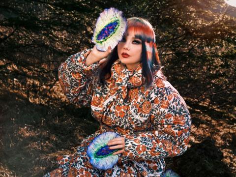 Björk Guðmundsdóttir, situr utandyra.