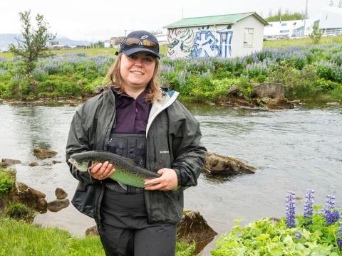 Marta Wieczorek holds the first salmon of the summer 2024 by Elliðaárnar