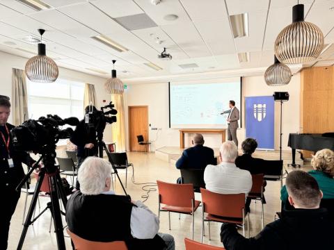 Frá fundi borgarstjóra um uppbyggingu húsnæðis í Borgum 26. júní 2024. Horft aftan á fundargesti, Einar kynnir efni á glærum.