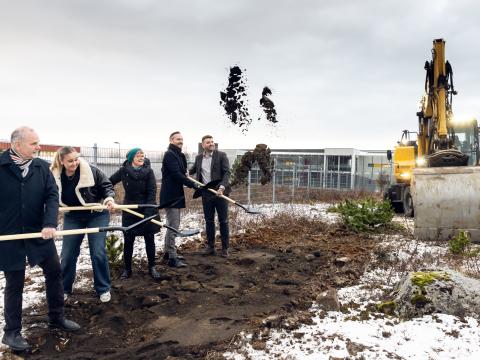 Óskar Jósefsson forstjóri FSRE, Lovísa Margrét Eðvarðsdóttir formaður nemendafélags FB, Guðrún Hrefna Guðmundsdóttir skólameistari FB, Einar Þorsteinsson borgarstjóri og Ásmundur Einar Daðason, mennta- og barnamálaráðherra, taka fyrstu skóflustungurnar að nýrri byggingu fyrir verknám í FB. Standa í röð og sveifla mold upp í loft af skóflunum, grafa í bakgrunni hægra megin.