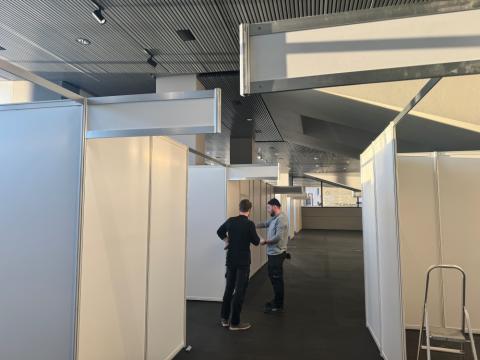 Tveir menn skoða teikningar í Tjarnarsal þar sem verið er að setja upp kjörklefa