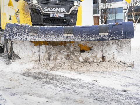 snjóplógur að keyra um götu.