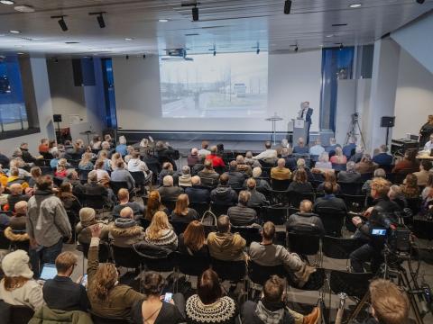 Yfirlitsmynd yfir þéttsetinn fundarsal.