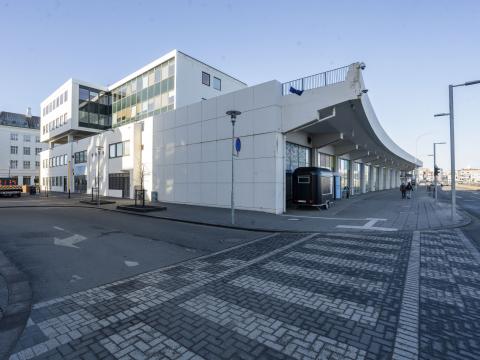 Tryggvagata 19 (Kolaportið). Myndað á ská frá Hafnartorgi sirka. Blár himinn, gatan í forgrunni.