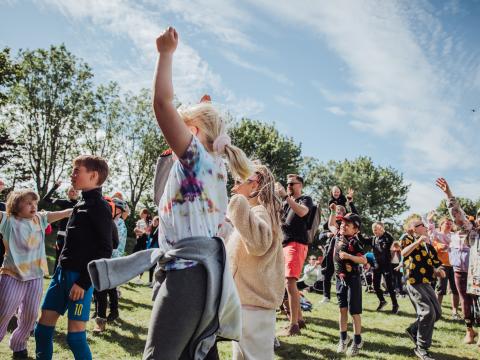 Börn í stuði að dansa í góðu veðri á sumarhátíð í Fjölskyldugarðinum.
