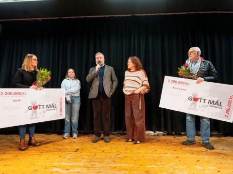 Five people pose with two ceremonial checks