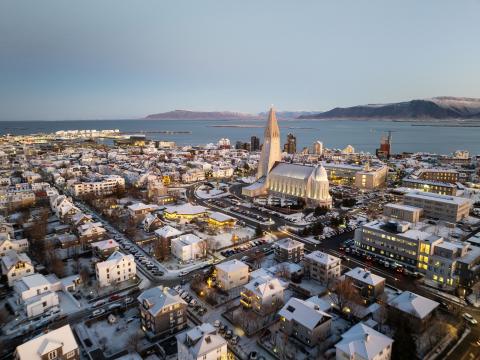 Loftmynd yfir miðborgina, Hallgrímskirkja áberandi fyrir miðju, Faxaflói og fjöllin í fjarska. Heiðskýrt, vetrarbirta.