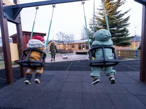Preschool children in swings.
