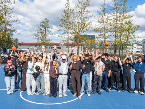 Hópur af ungmennum með borgarstjóra á körfuboltavellinum endubætta í Völvufelli.