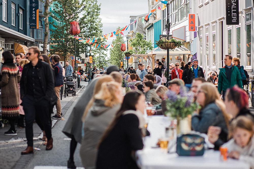 Fólk situr að snæðingi við langborð á göngugötunni Laugarvegi.