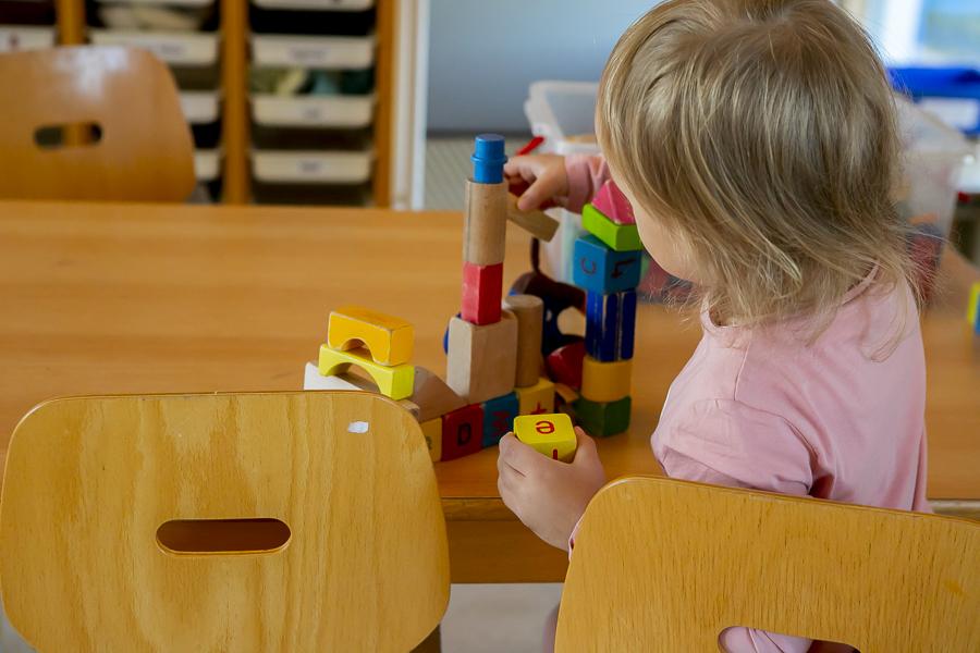 A girl stacks blocks inside Blásalir.