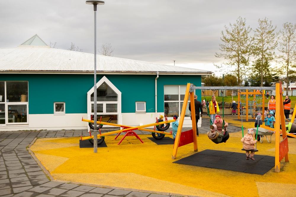 Börn að róla sér og vega salt á útisvæði leikskólans Gullborgar