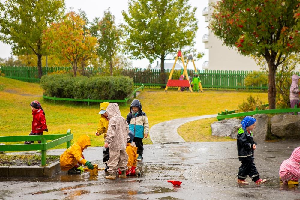 Börn og leiktæki á lóð Hagaborgar.