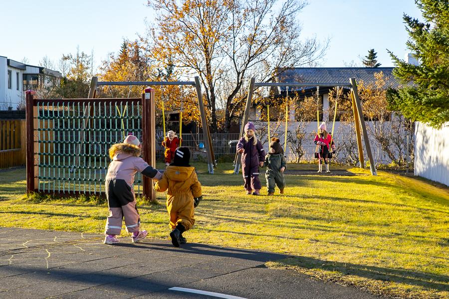 Börn og leiktæki á lóð Heiðarborgar.