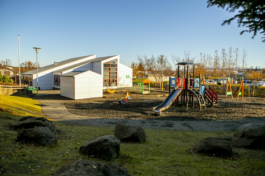 Sandkassi og leiktæki á lóð Rauðuborgar.