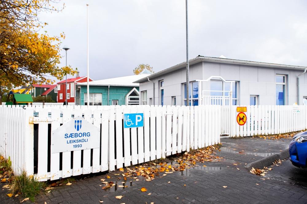 Ljósmynd af húsnæði leikskólans Sæborgar og hvítu grindverki.