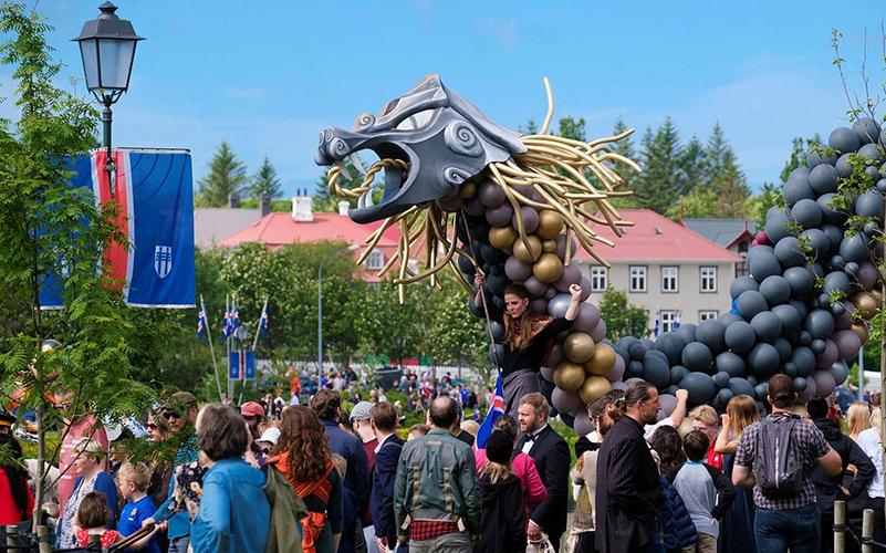 Fólk og risavaxinn dreki í skrúðgöngu á 17. júní.