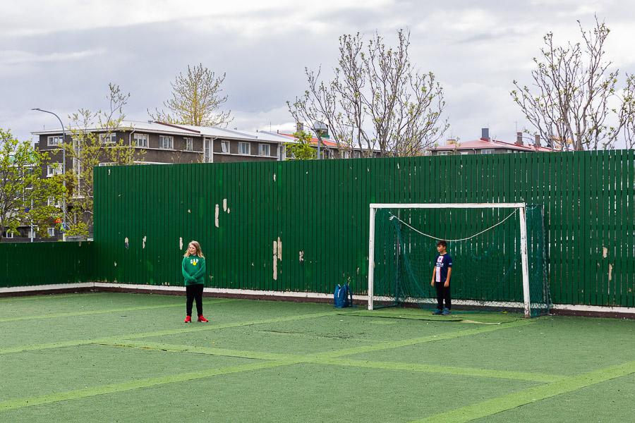 A soccer field and children playing soccer. 