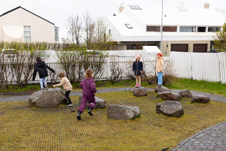 Hópur af börnum að leika sér á steinum á útisvæði Undralands.