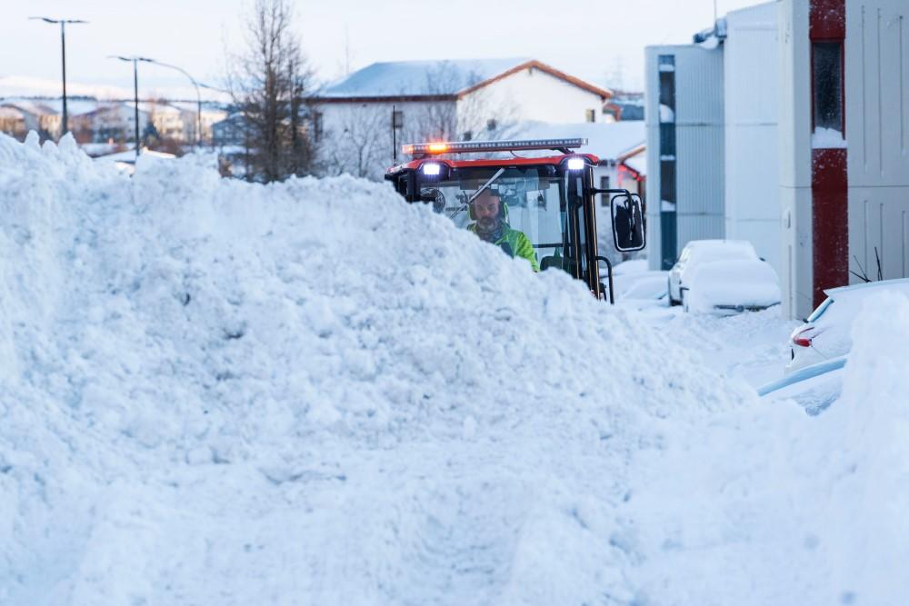 Snjóruðningstæki hreinsar snjó af göngustíg í Breiðholti.