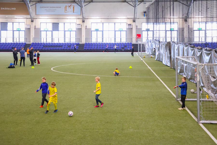 Children playing soccer in the sports hall. 