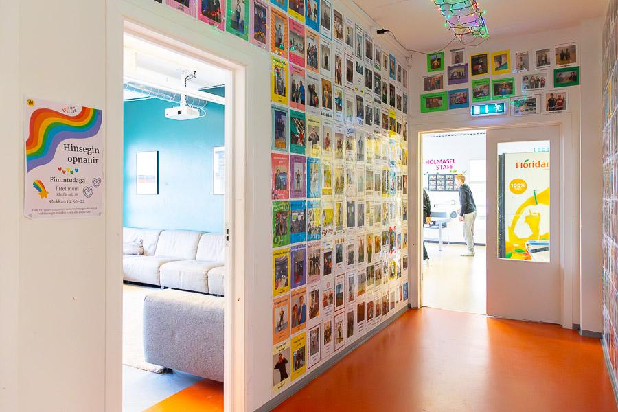 Hallway decorated with pictures of young people. View into the lounge and room with a ping-pong table.