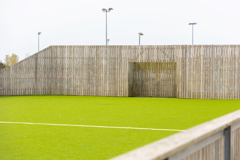 Útifótboltavöllur umkringdur girðingu. 