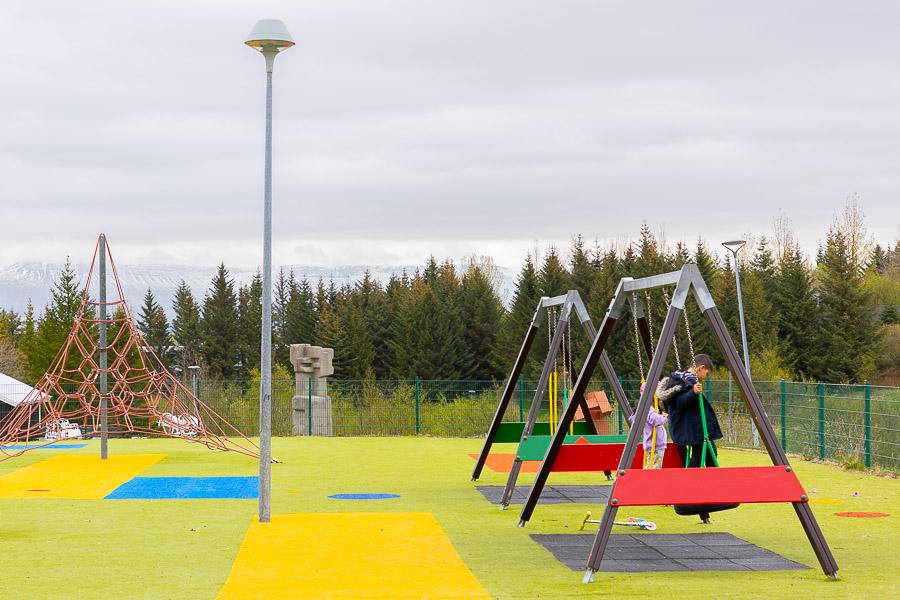 Marglitur leikvöllur með klifurgrind og rólum.