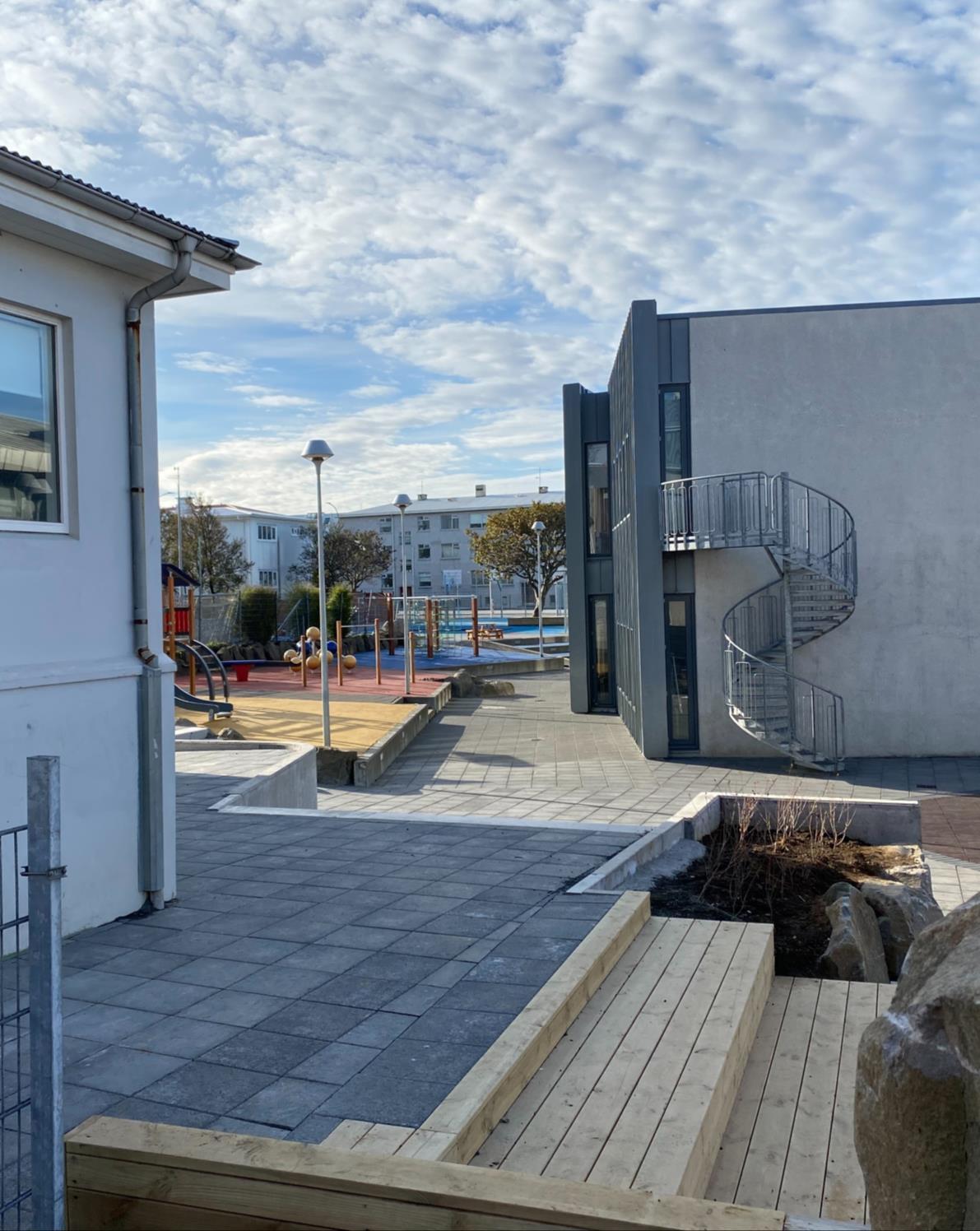 A paved area, a building, and a play area.