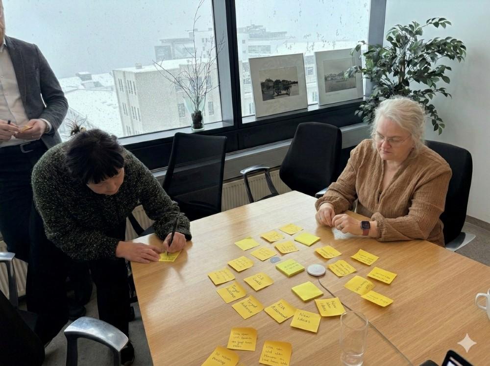 Workshop participants write ideas on Post-it notes.
