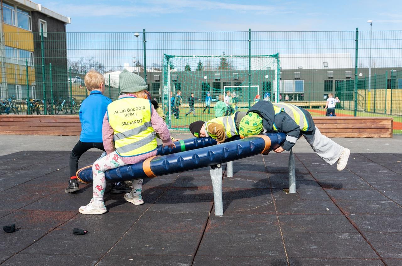 Children playing on playground equipment on the school grounds.