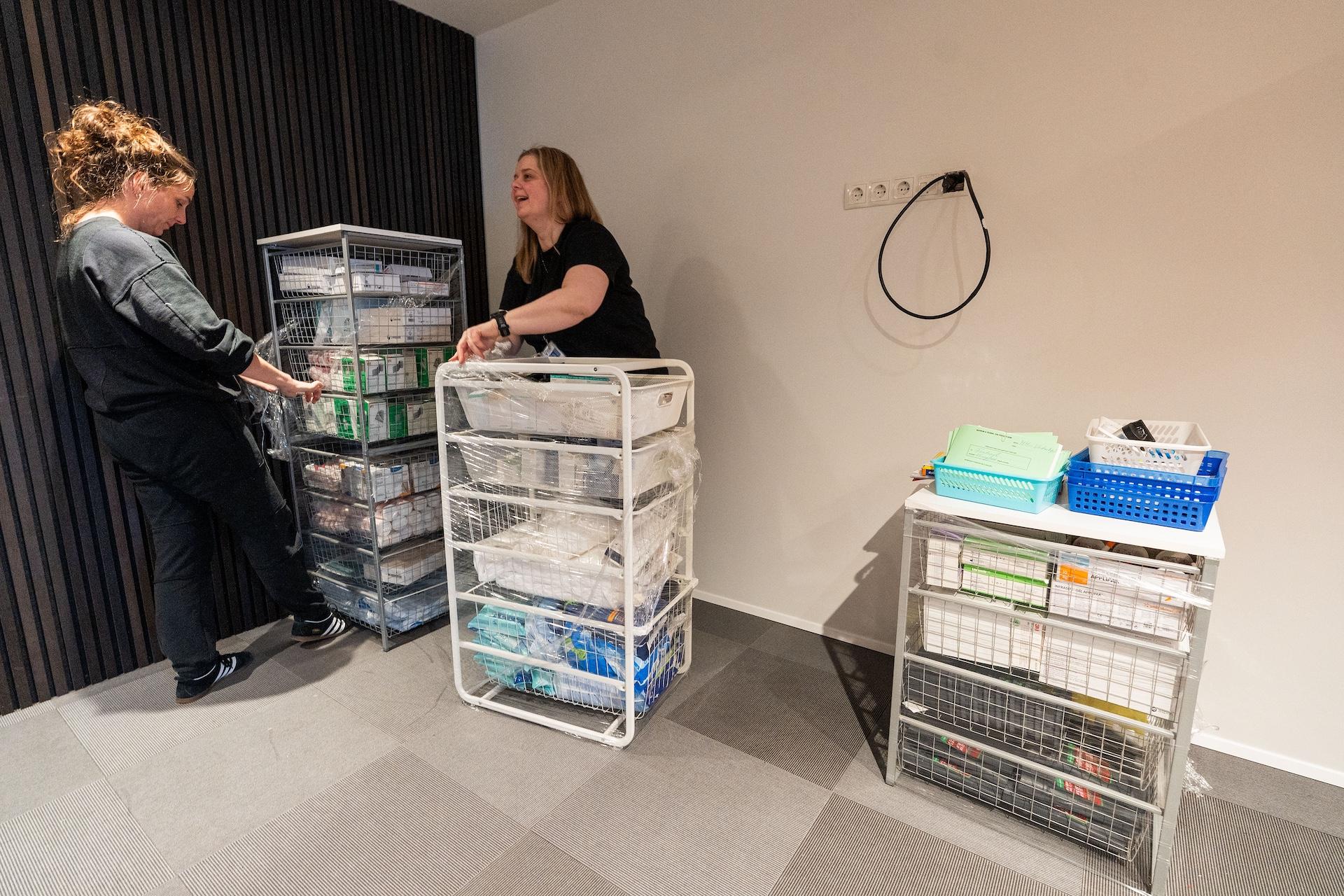 Tveir hjúkrunarfræðingar sem eru að raða hlutum inn í nýjan starfsstað í Lágmúla. 