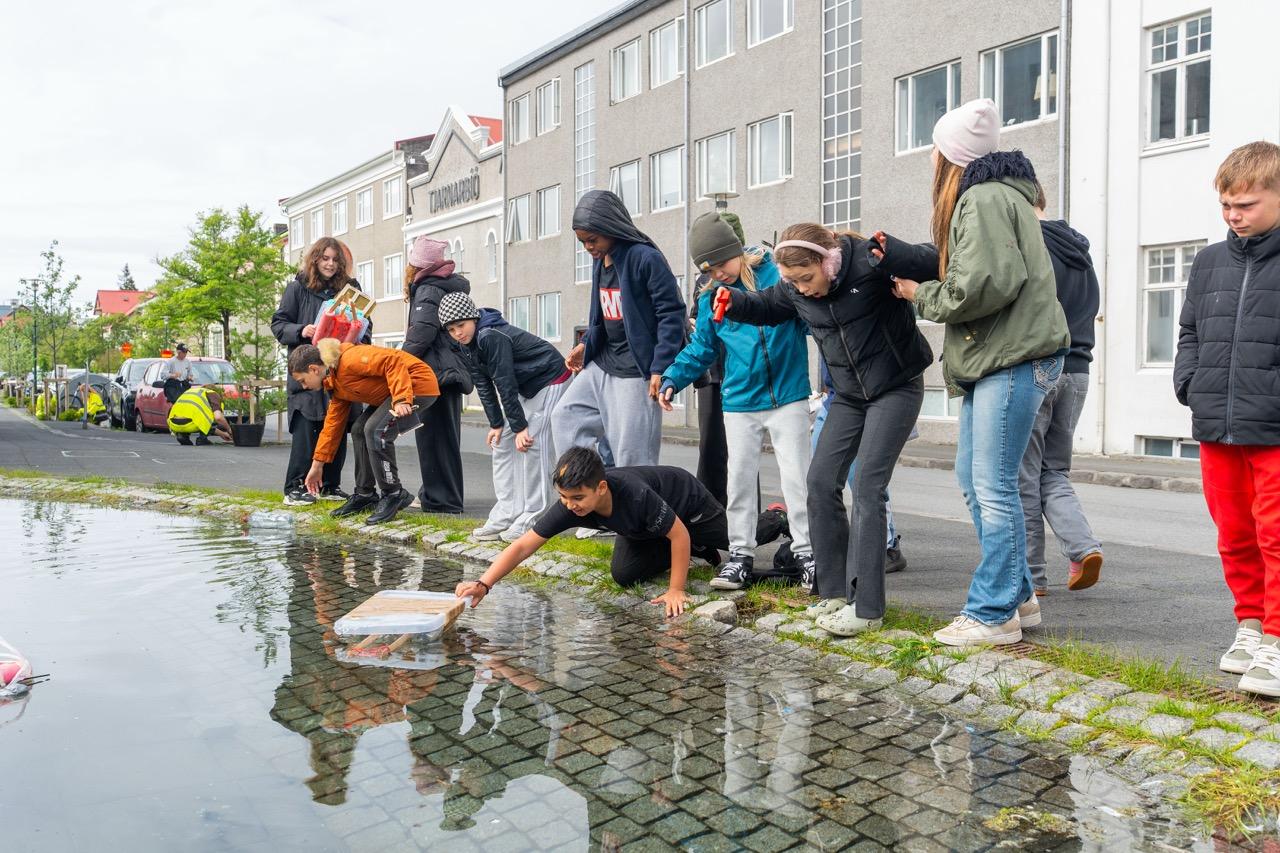 Mynd af bátum og nemendum í bátaleikunum