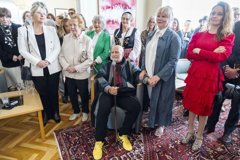 Egill Ólafsson sitjandi ásamt fjölskyldu sinni og velunnurum