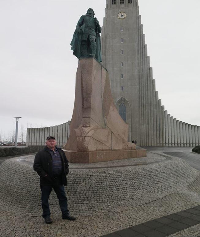 Einar D. G. Gunnlaugsson við styttu Leifs Eiríkssonar. Hallgrímskirkja í baksýn.