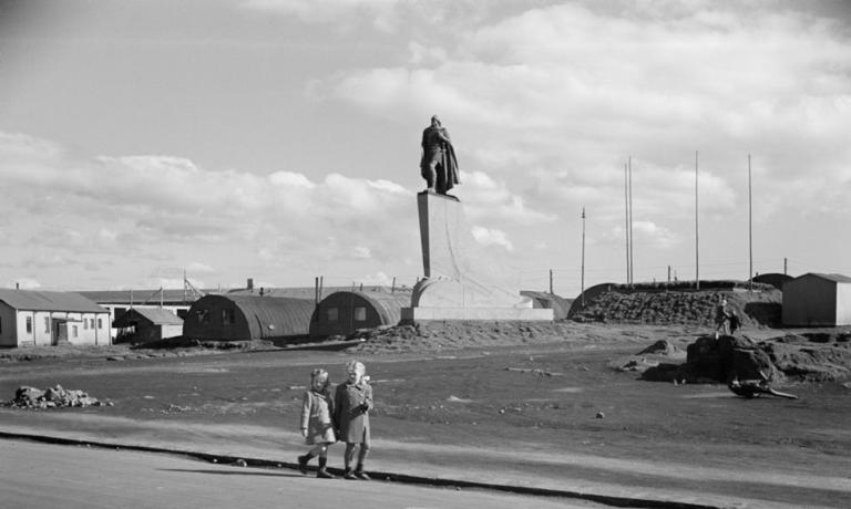 Svarthvít mynd frá braggahverfinu á Skólavörðuholti. Tvær ungar stúlkur í forgrunni, stytta Leifs Eiríkssonar í baksýn.