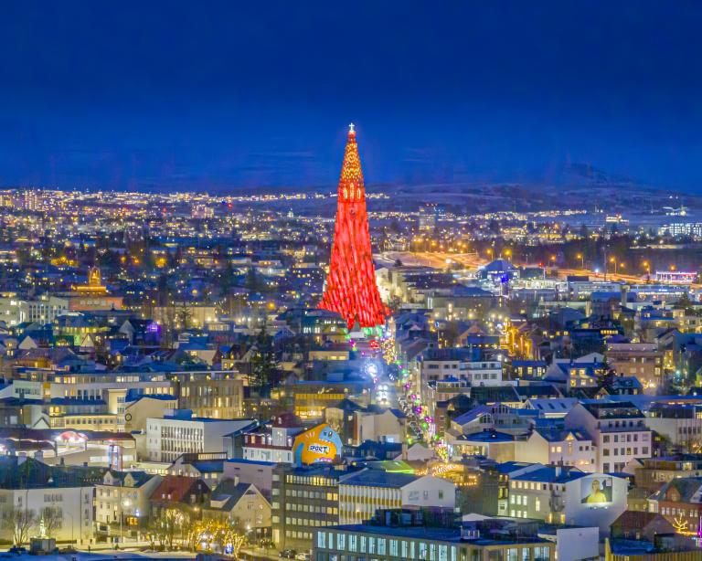 Loftmynd af borginni á Vetrarhátíð. Kvöld, yfirlit yfir Þingholt, turn Hallgrímskirkju gnæfir yfir lýstur í rauðu