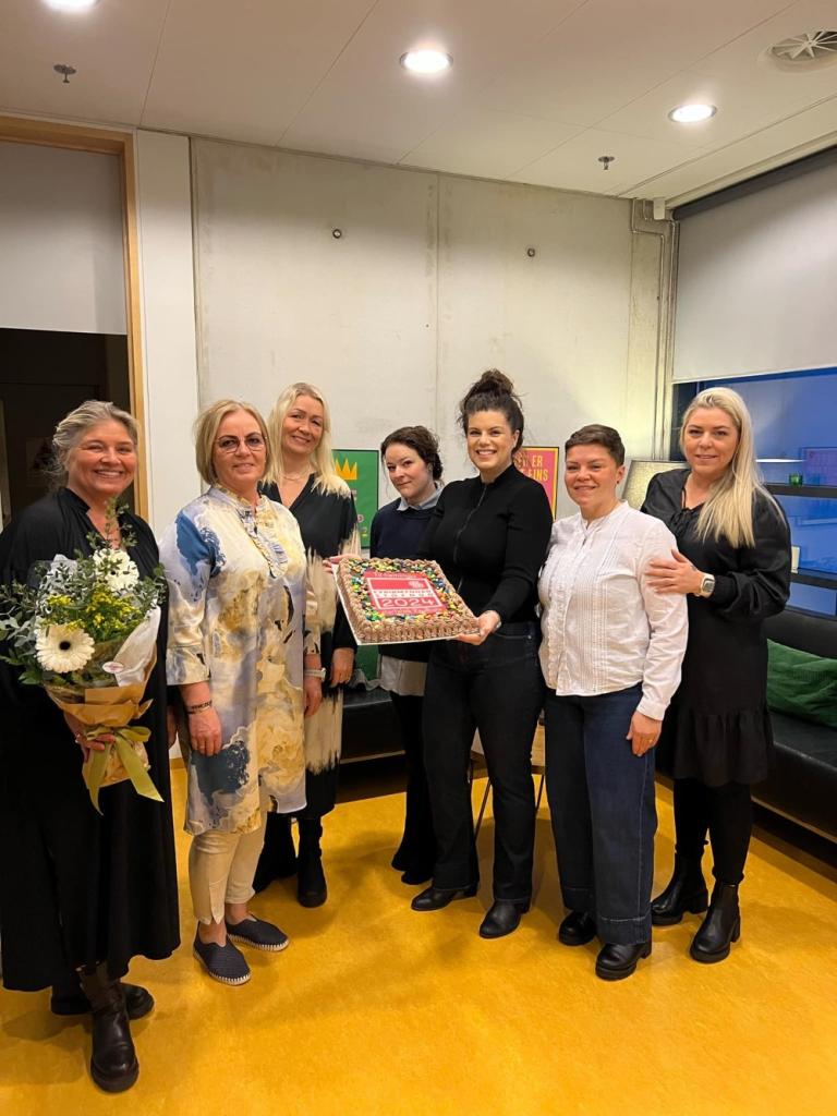 Staff at Rauðhóll preschool receiving cake and flowers.