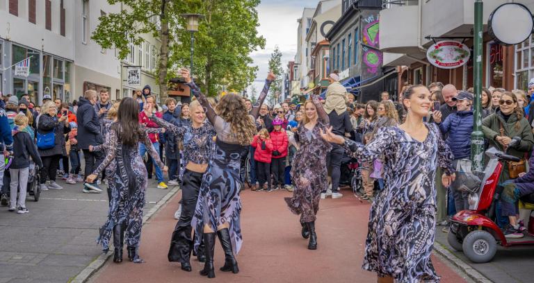 Dansatriði á Menningarnótt, konur í sams konar kjólum dansa á rauða hluta Laugavegar