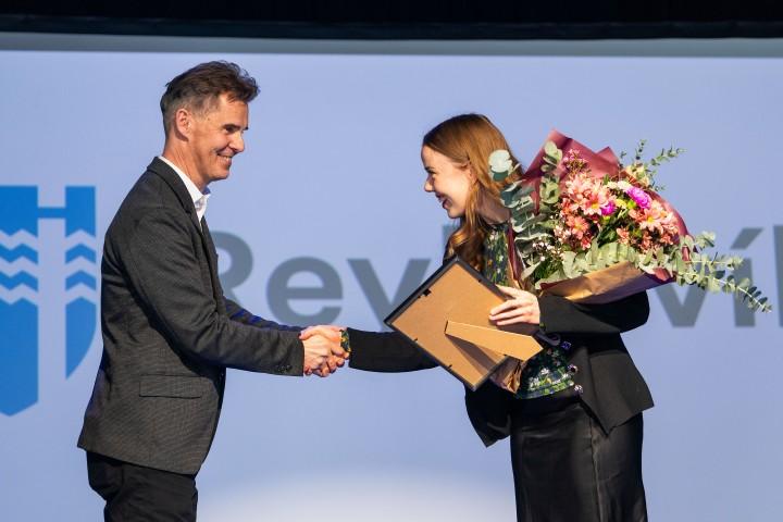 Skúli Þór Helgason formaður menningar- og íþróttaráðs afhendir Önnu E. Sigurðardóttur í stjórn Elju tekur við styrknum og blómvendi í Iðnó.
