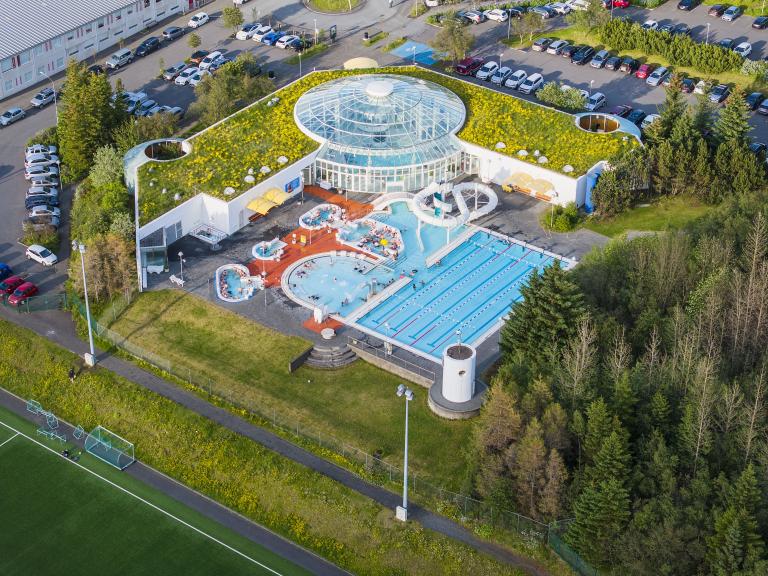 Angled aerial view of Árbæjarlaug pool, green vegetation, summer