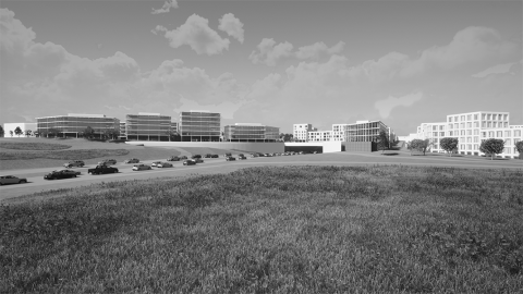 Black-and-white photo of a structure. Large buildings along a traffic street.