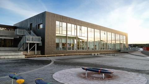 Picture of a large gray building with a window side where the youth center Plútó is located