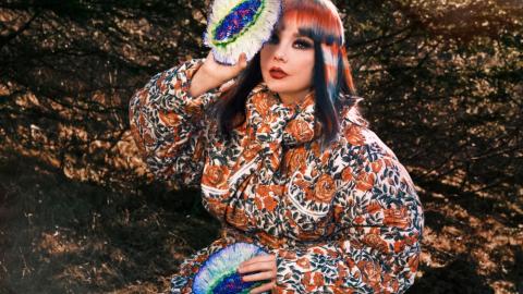 Björk Guðmundsdóttir, situr utandyra.