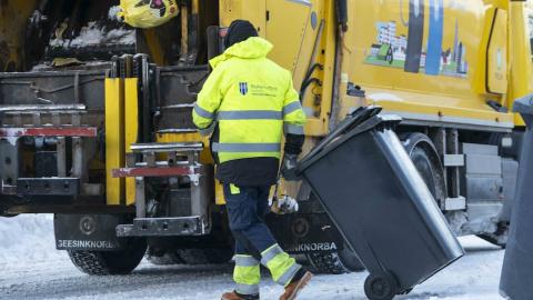 Sorpbíll, starfsmaður með tunnu. Snjór á jörð.