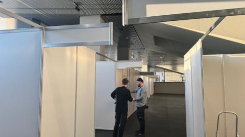 Tveir menn skoða teikningar í Tjarnarsal þar sem verið er að setja upp kjörklefa
